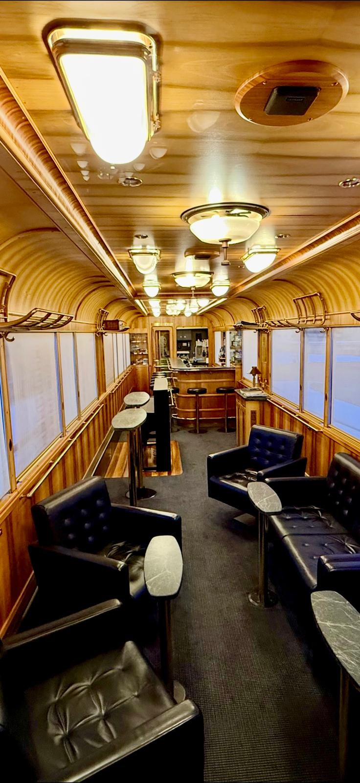 Piano Bar wagon interior with polished wood panelling, brass fittings and dark leather armchairs